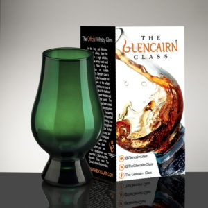 Green glencairn whiskey glass with packaging gray background
