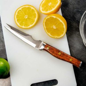 bar knife on cutting board next to oranges