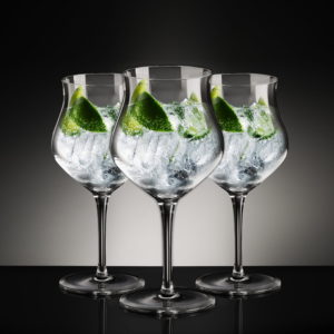 Three Glencairn Gin Goblets filled with gin and garnish